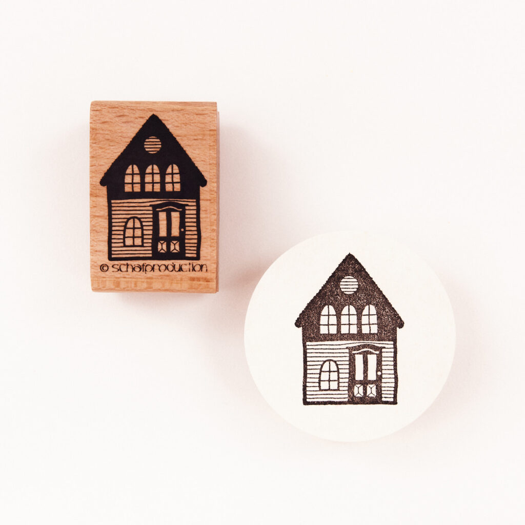 Ein detailreicher Holzstempel mit dem Motiv eines Hauses mit Holzvertäfelung, kunstvoll gestaltet und ideal für kreative Papeterie-Projekte.